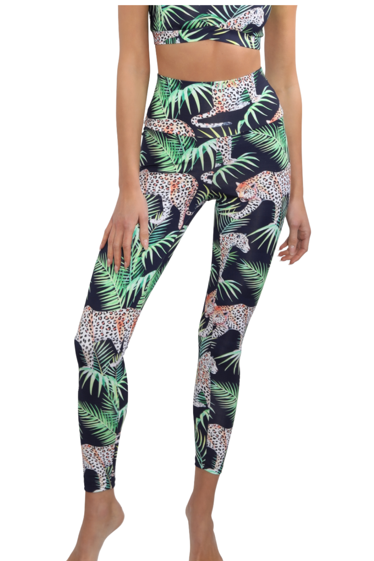 Person wearing a tropical leaf and leopard print leggings set on a white background